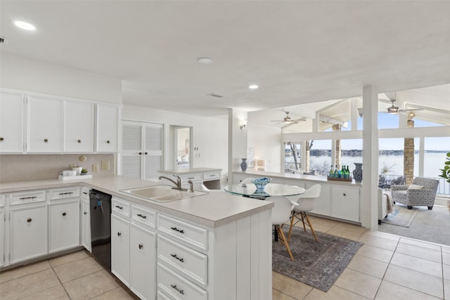 kitchen with sink, dishwasher, white cabinetry, and light tile patterned floors