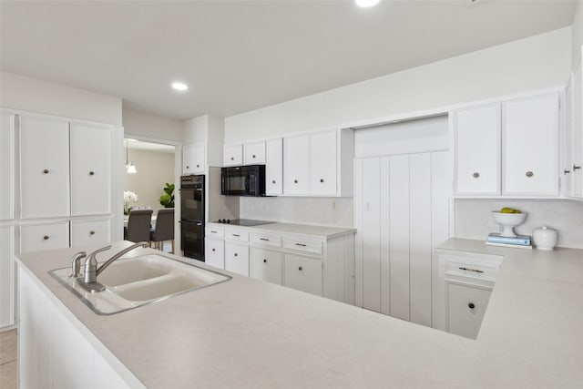 kitchen with sink, white cabinets, and black appliances