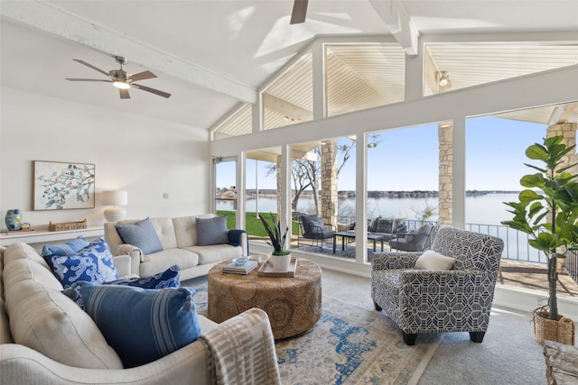 living room with a water view, lofted ceiling with beams, ceiling fan, and carpet flooring