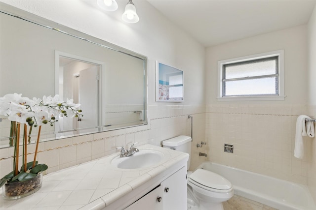 bathroom with toilet, vanity, and tile walls