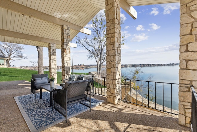 view of patio / terrace with a balcony, outdoor lounge area, and a water view