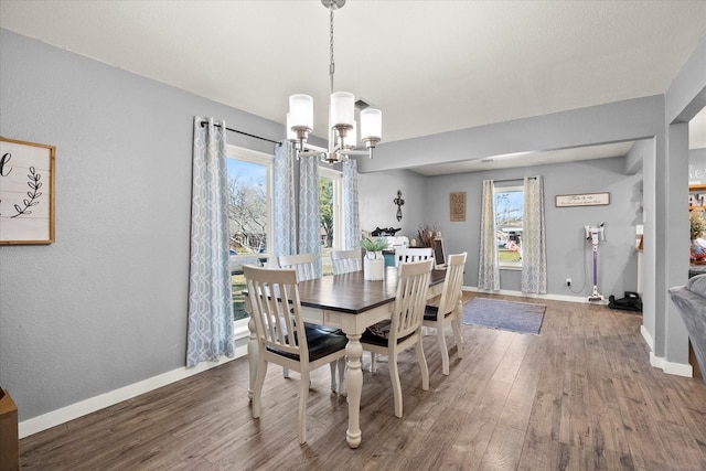 dining room featuring a notable chandelier, a wealth of natural light, and hardwood / wood-style flooring