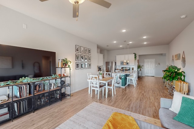 living room featuring ceiling fan and light wood-type flooring