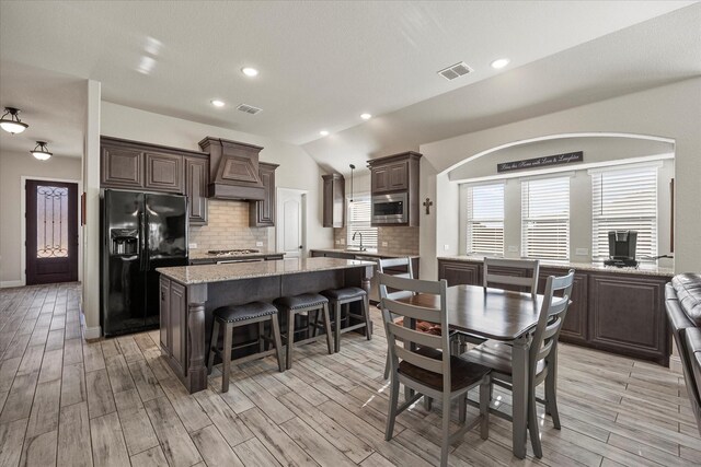 kitchen featuring baseboards, appliances with stainless steel finishes, dark brown cabinetry, and visible vents