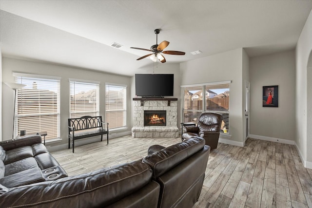 living room with ceiling fan, a fireplace, and light hardwood / wood-style flooring