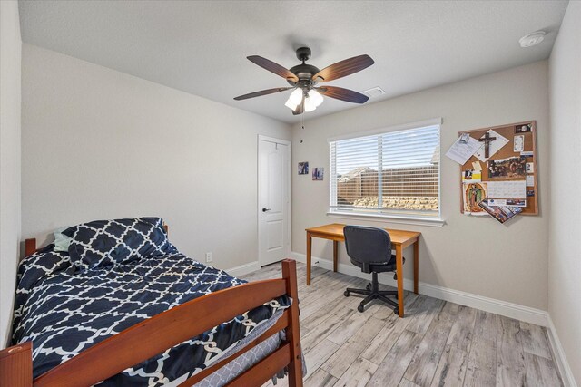 bedroom with baseboards, ceiling fan, light wood-style flooring, and visible vents