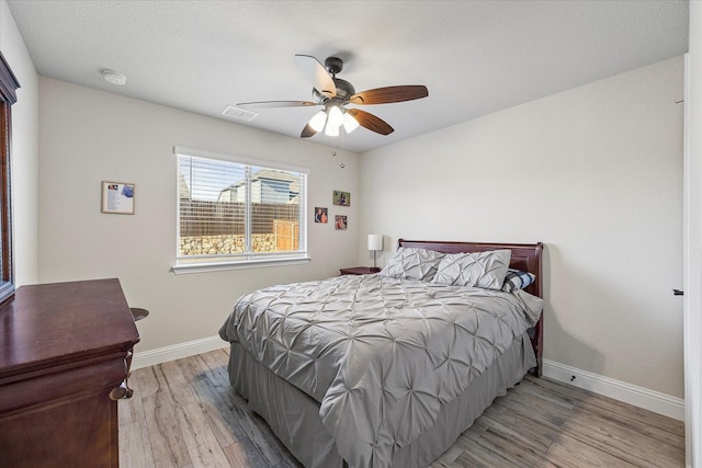 bedroom featuring baseboards, ceiling fan, and wood finished floors