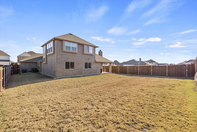 rear view of house featuring a lawn and central air condition unit