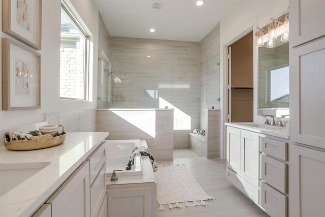 bathroom with vanity and independent shower and bath