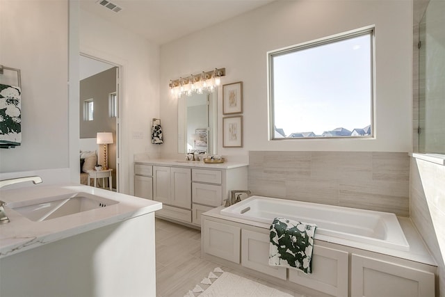 bathroom featuring vanity and a bath