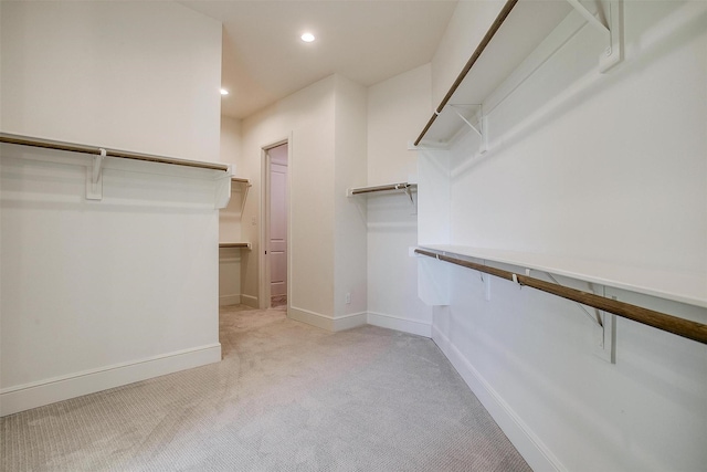 spacious closet featuring light colored carpet