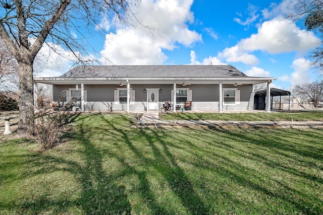 rear view of property featuring a porch, a carport, and a yard