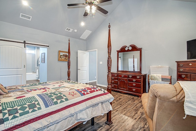 bedroom featuring ceiling fan, a barn door, ensuite bath, hardwood / wood-style flooring, and high vaulted ceiling