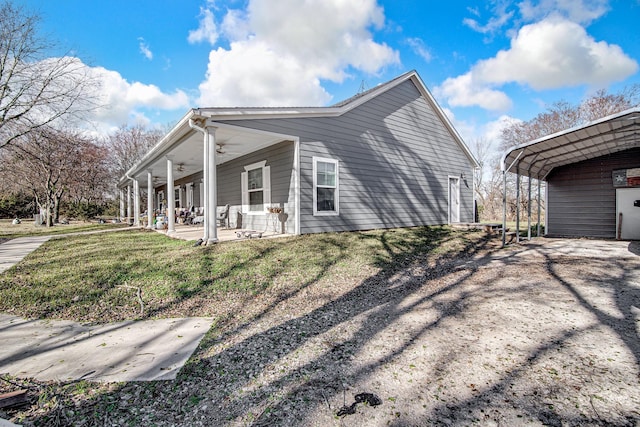 view of home's exterior with ceiling fan, a yard, and covered porch