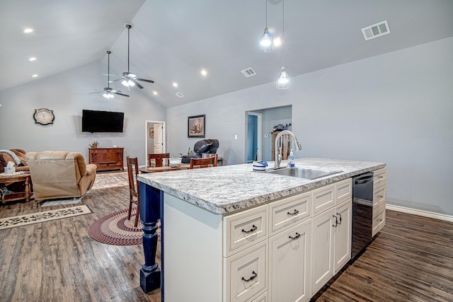 kitchen featuring decorative light fixtures, sink, black dishwasher, white cabinetry, and a kitchen island with sink