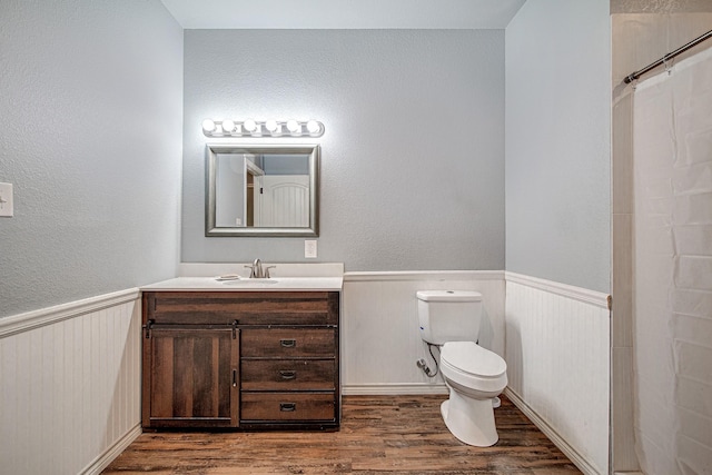 bathroom featuring toilet, a shower with curtain, hardwood / wood-style floors, and vanity