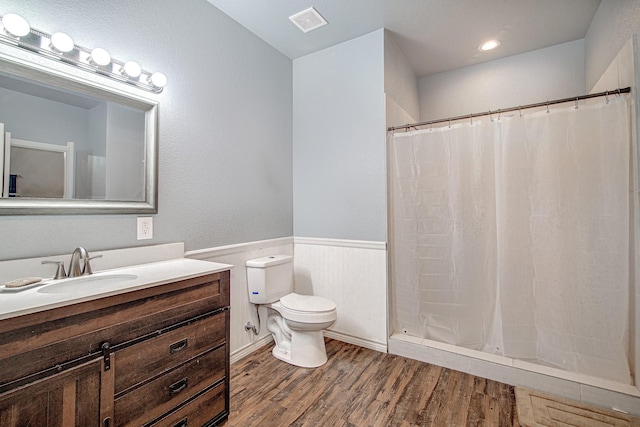 bathroom featuring toilet, vanity, walk in shower, and hardwood / wood-style floors