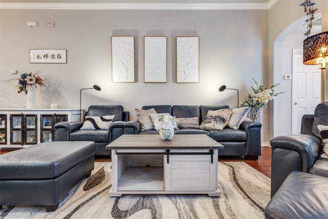 living room with ornamental molding, arched walkways, and wood finished floors