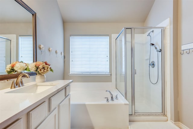 bathroom featuring a stall shower, a garden tub, and vanity