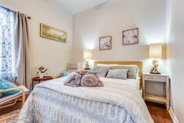 bedroom with baseboards and dark wood-type flooring