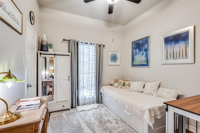 bedroom with a barn door and a ceiling fan