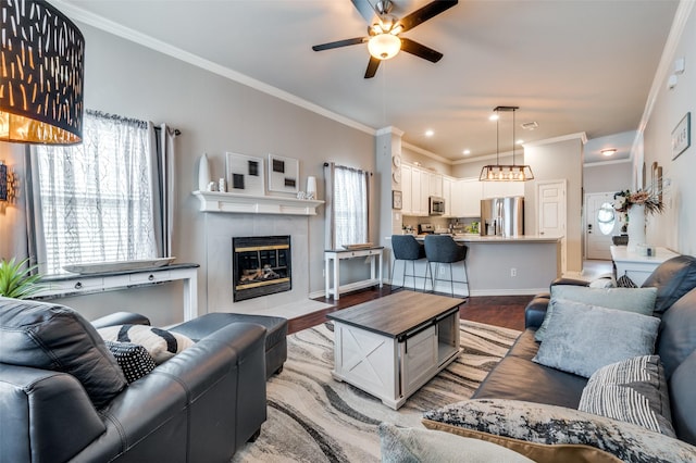 living room with crown molding, a fireplace, and light wood-style flooring