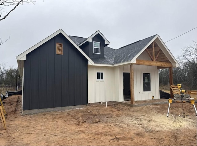 exterior space featuring board and batten siding and a shingled roof