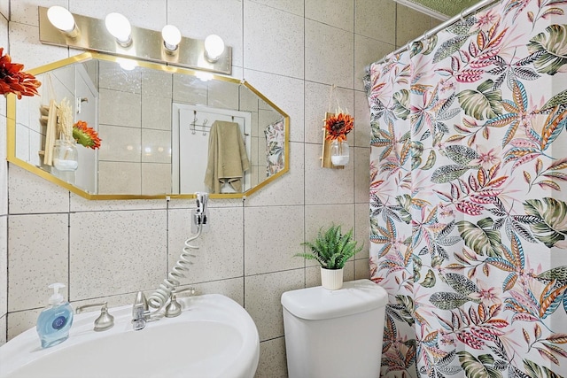 bathroom featuring toilet, tile walls, sink, and curtained shower