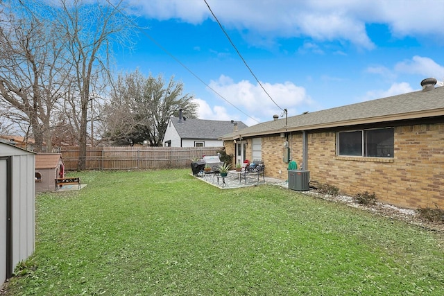 view of yard featuring central AC, a storage unit, and a patio area