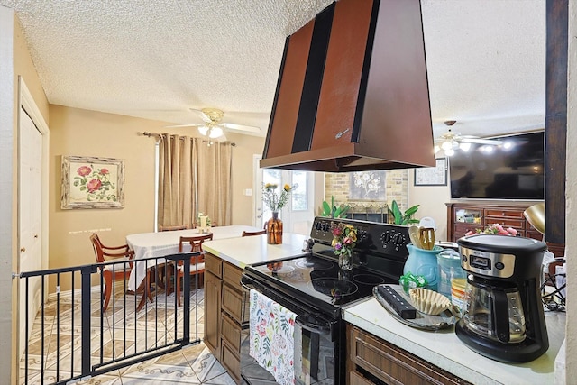 kitchen featuring electric range, light tile patterned floors, a textured ceiling, and extractor fan