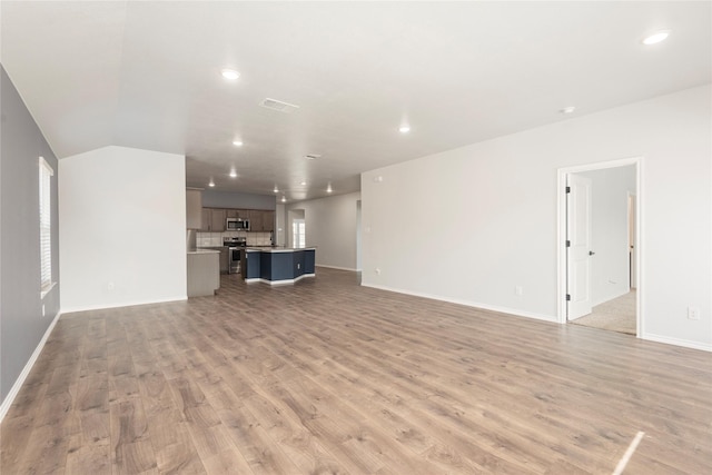 unfurnished living room with recessed lighting, light wood-style floors, visible vents, and baseboards