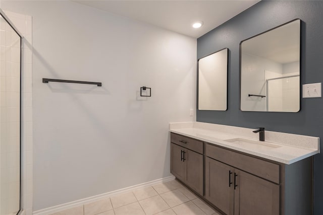 bathroom with tile patterned flooring, a shower stall, vanity, and baseboards