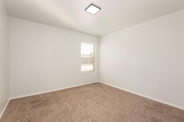 carpeted spare room with baseboards