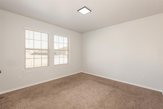 empty room featuring carpet flooring and baseboards