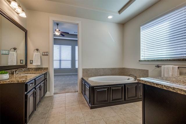 bathroom featuring ceiling fan, vanity, tile patterned floors, a bath, and a raised ceiling