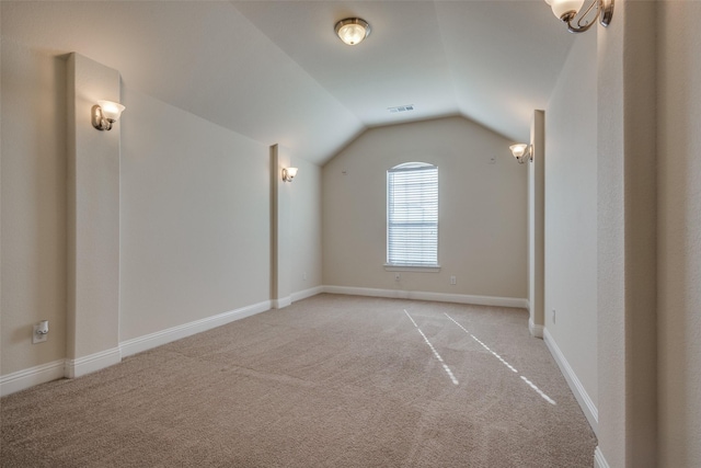 additional living space with vaulted ceiling and light colored carpet