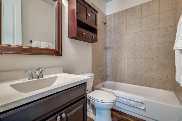 full bathroom with toilet, tiled shower / bath combo, wood-type flooring, and vanity