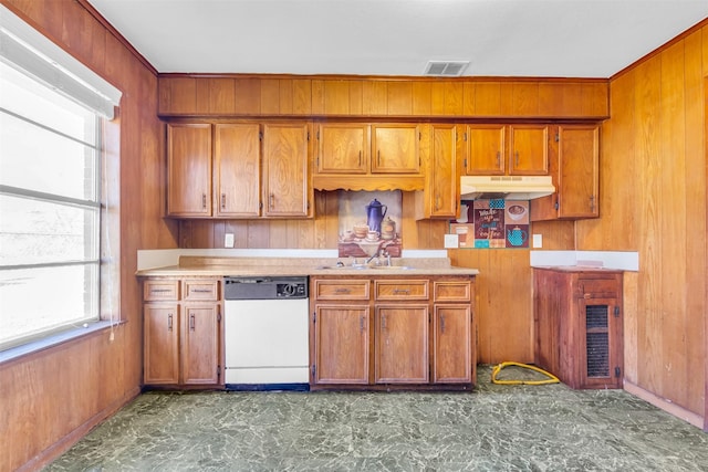 kitchen featuring wood walls, sink, and white dishwasher