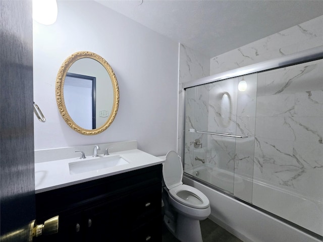 full bathroom with enclosed tub / shower combo, vanity, and toilet