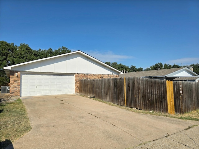 view of side of property with central AC unit and a garage