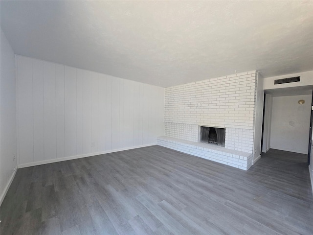 unfurnished living room featuring a fireplace and dark hardwood / wood-style floors