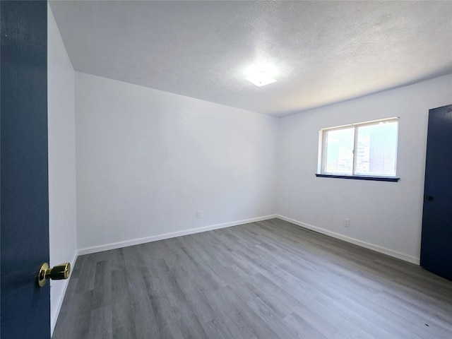 spare room featuring a textured ceiling and hardwood / wood-style floors