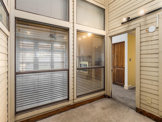 interior space featuring wooden walls and concrete floors