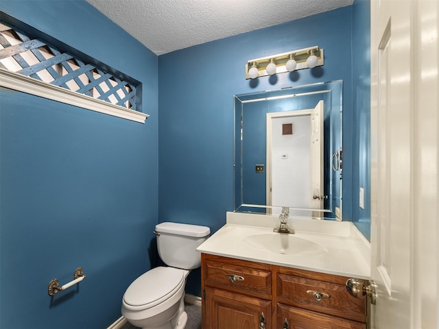 bathroom featuring toilet, vanity, and a textured ceiling