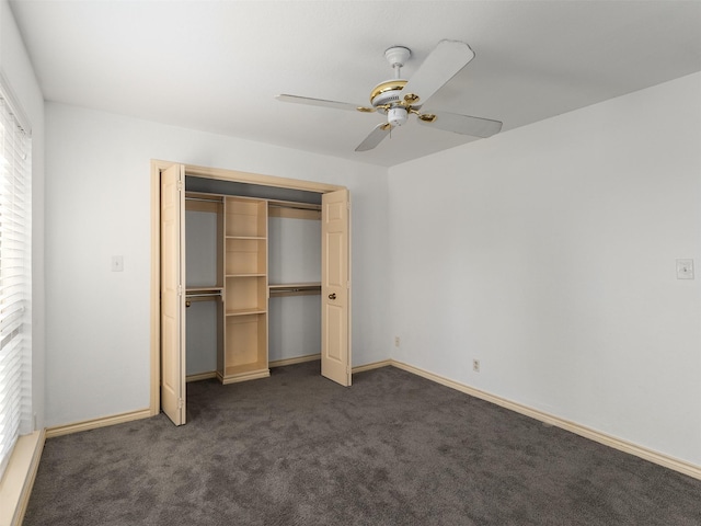 unfurnished bedroom featuring ceiling fan, a closet, and dark colored carpet