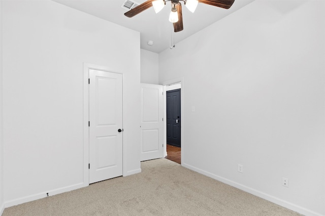 unfurnished bedroom with ceiling fan, light carpet, and a closet