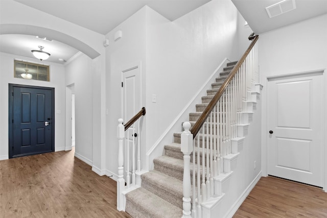 foyer entrance with ornamental molding and hardwood / wood-style flooring