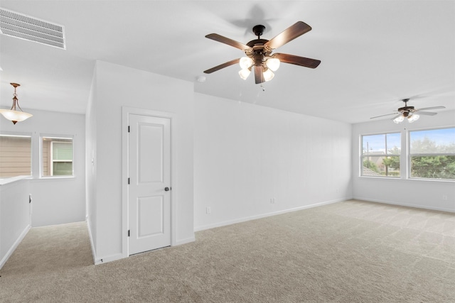 empty room featuring ceiling fan and light carpet