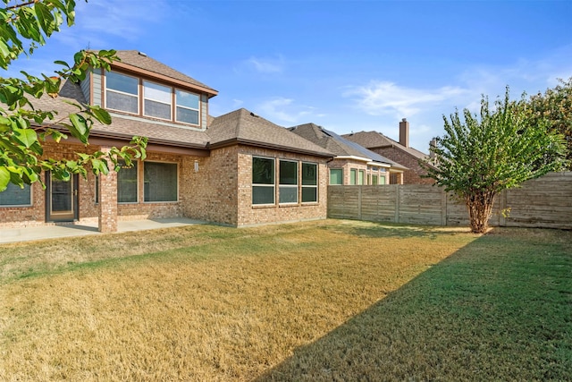 back of house with a patio area and a yard