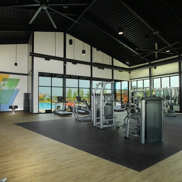 exercise room with high vaulted ceiling and hardwood / wood-style floors